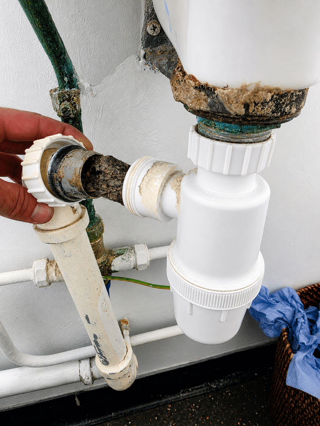 Emergency plumber in Inchicore renewing a corroded sink waste pipe beside a bottle trap